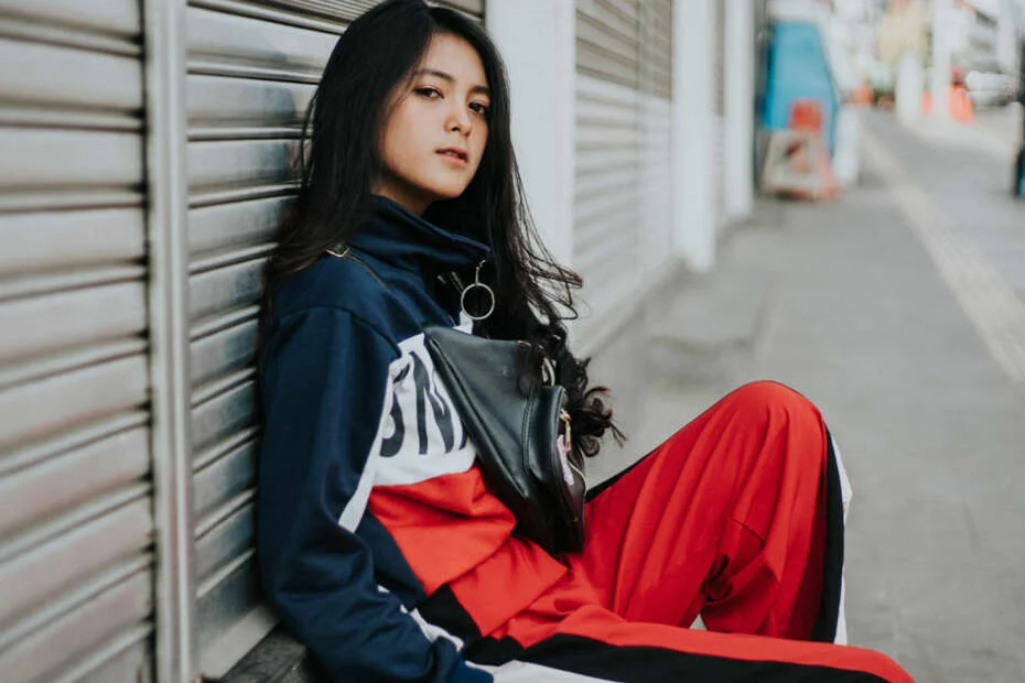 Woman wearing casual streetwear outfits women can style with a graphic hoodie and cap