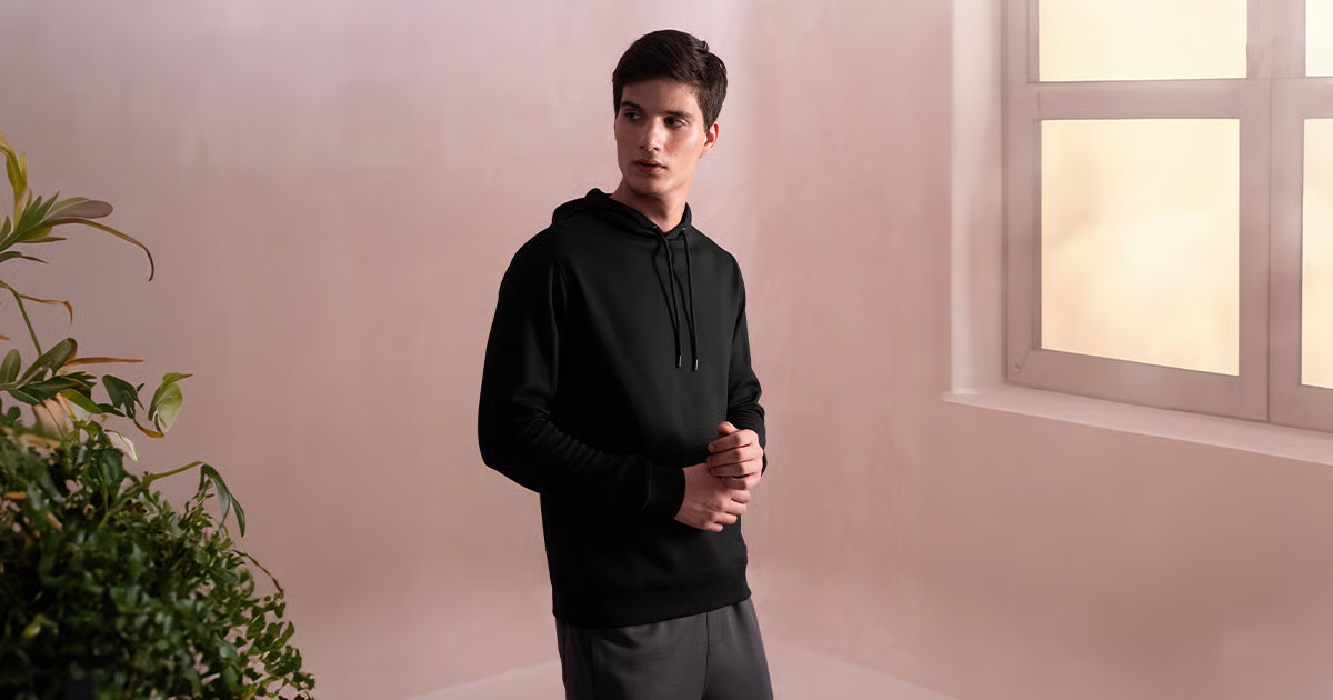 Man wearing a hoodie showing how to style hoodies with sweatpants and a jacket